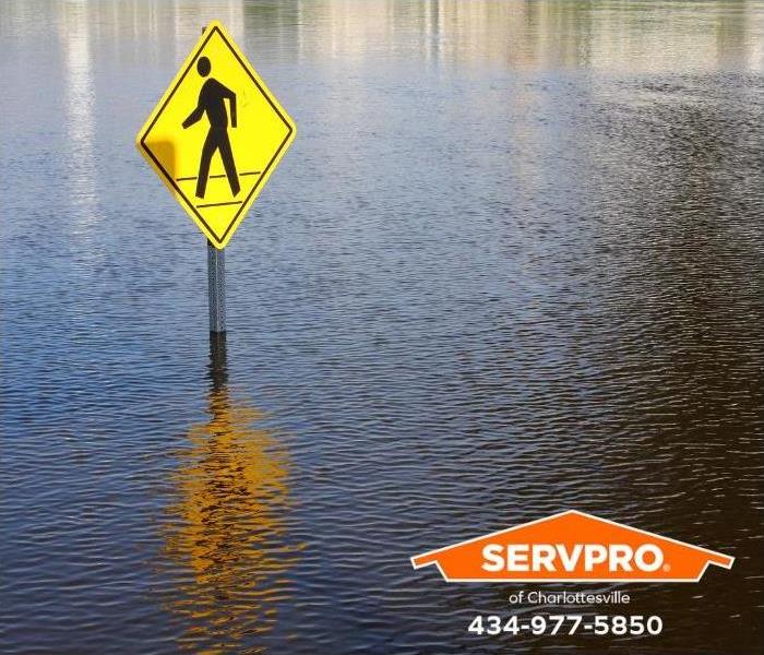 A street sign is submerged in floodwaters.