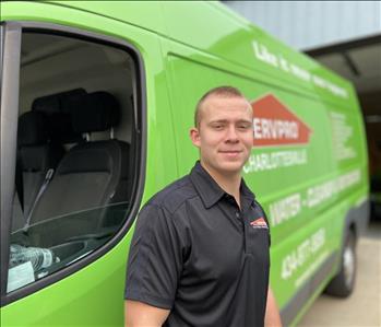 The owner standing in front of a SERVPRO of green Charlottesville vehicle